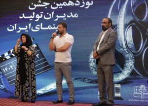 فرزند شهید همت(راست) در کنار پوران درخشنده و پژمان بازغی برای اهدای جایزه فیلم قهرمان روی سن آمد